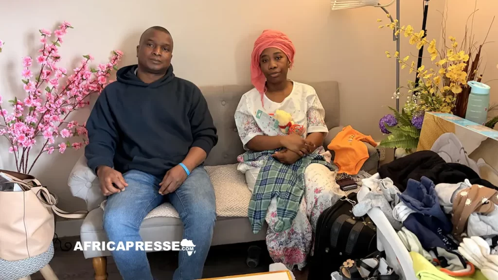 Kouamé et Ruth Koffi dans leur salon, entourés des affaires achetées pour leur bébé.